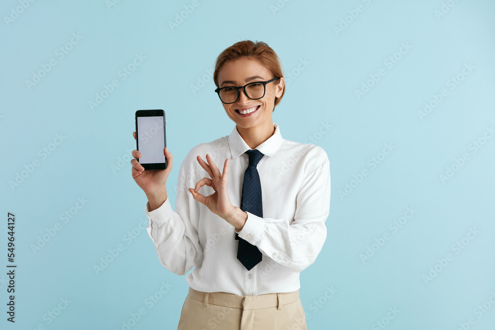 Happy Businesswoman Showing Smartphone. Caucasian Lady Smiling while Showing Cellphone, Recommended App, Enjoying Mobile Service. Empty Copy Space for Advertisement, Indoor Studio Shot Happy Businesswoman Showing Smartphone. Caucasian Lady Smiling while Showing Cellphone, Recommended App, Enjoying Mobile Service. Empty Copy Space for Advertisement, Indoor Studio Shot