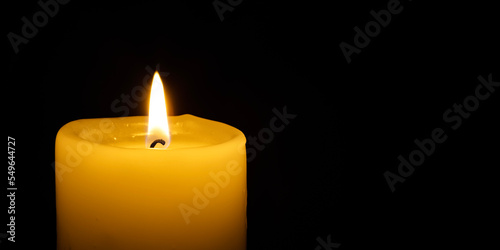 a burning candle on the black backgrounds