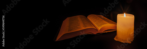 Vászonkép bible on the table in the light of a candle