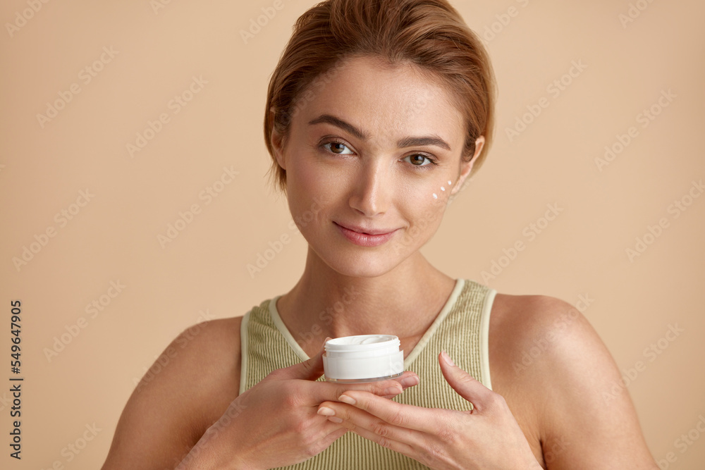 Beauty Woman Applying Face Cream. Closeup Of Female Model With Fresh Skin Holding Cream Bottle In Hand. Portrait Of Sexy Girl Applying Cosmetic Product Under Eyes. Skincare Concept. High Resolution Beauty Woman Applying Face Cream. Closeup Of Female Model With Fresh Skin Holding Cream Bottle In Hand. Portrait Of Sexy Girl Applying Cosmetic Product Under Eyes. Skincare Concept. High Resolution