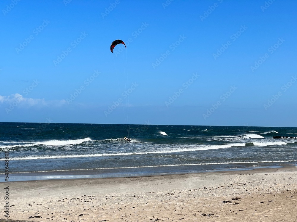 wide sandy beach blue sky with clouds visible waves over the baltic sea