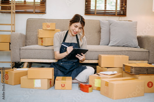 Small business entrepreneur SME freelance woman working at home office, BOX,tablet and laptop online, marketing, packaging, delivery,  e-commerce concept © Nuttapong punna