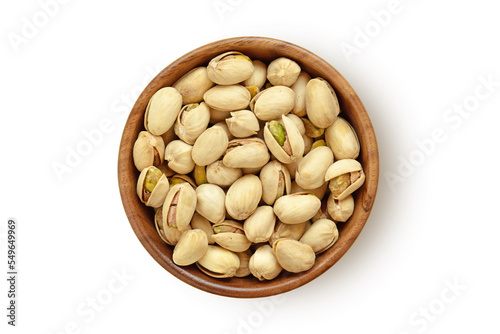 Pistachio nuts in wooden bowl on white background