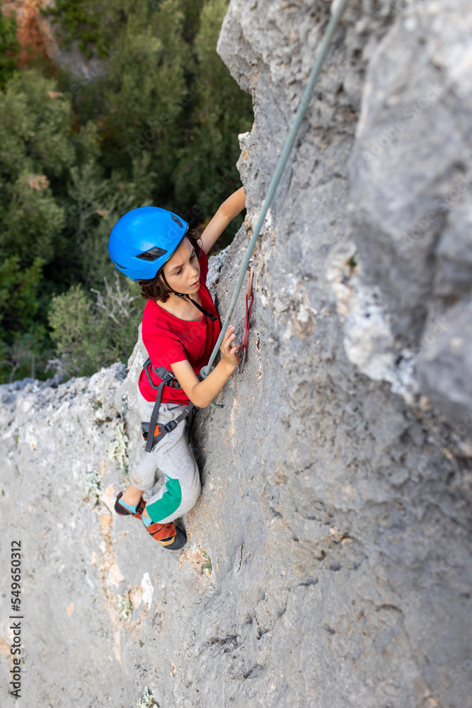 Fototapeta premium climber boy. the child trains in rock climbing.