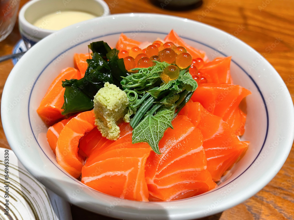 Fresh Salmon Sashimi Don or Salmon Sashimi with rice on top with wasabi on white bowl , Japanese restaurant, Japan Fresh Salmon Sashimi Don or Salmon Sashimi with rice on top with wasabi on white bowl , Japanese restaurant, Japan