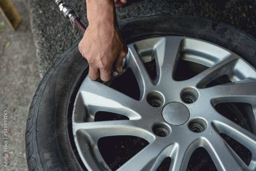 Adding air pressure into a newly vulcanized tire. Attaching an air hose into the valve stem. Adding air pressure into a newly vulcanized tire. Attaching an air hose into the valve stem.