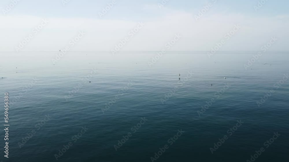 Abstract aerial sea summer ocean sunset nature background. Small waves on water surface in motion blur with golden bokeh lights from sun. Holiday, vacation and recreational concept. Slow motion