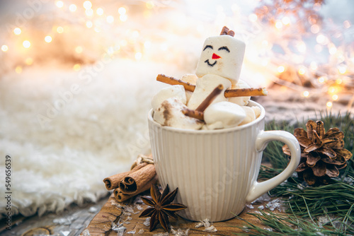 Christmas background with marshmallow snowman in a cup.