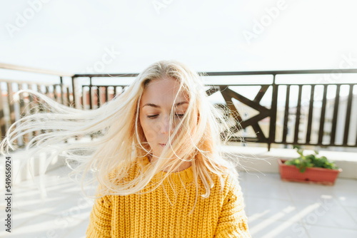 Blond woman with windswept hair on terrace