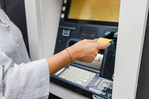 Hand of woman inserting credit card in ATM machine