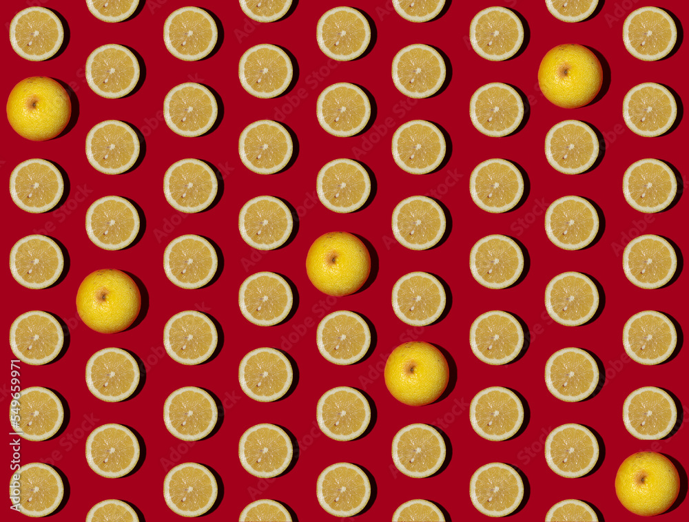 Pattern of halved lemons flat laid against red background Pattern of halved lemons flat laid against red background