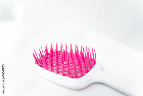 macro shot of the teeth of a white comb for hair extensions hair on isolated background