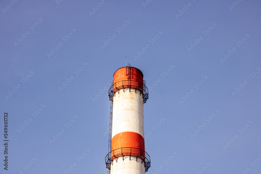 Red and white pipe of plant against background of blue sky Red and white pipe of plant against background of blue sky