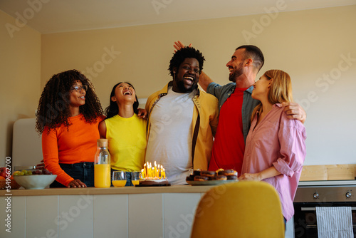 Multiethnic friends celebrate birthday at home.