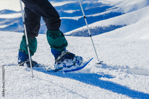 Snowshoe walker running in powder snow with beautiful winter landscape