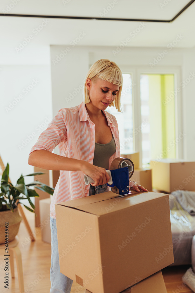 Caucasian woman packing cardboard boxes to move. Caucasian woman packing cardboard boxes to move.