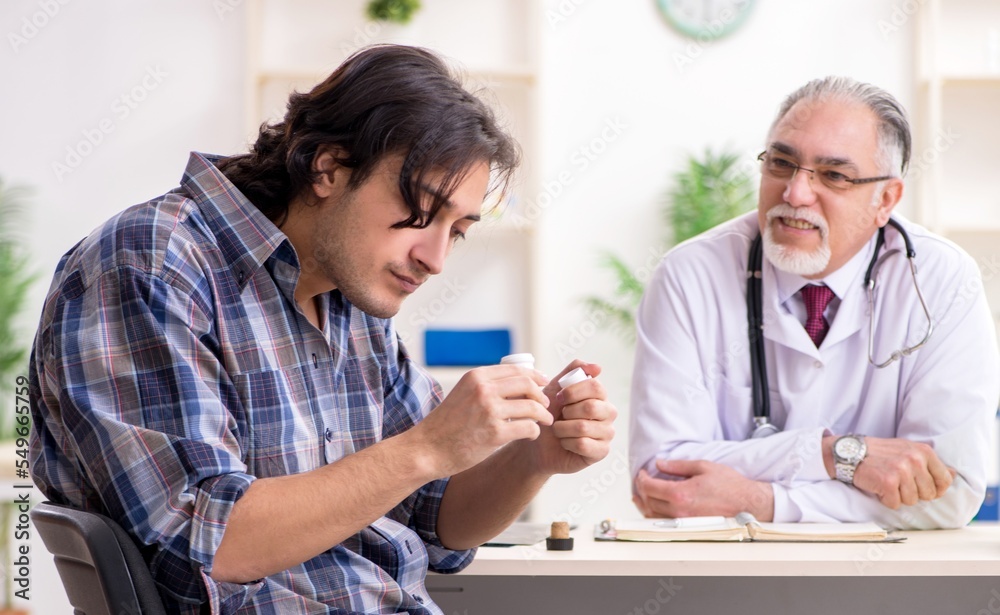 Young male alcoholic visiting old doctor Young male alcoholic visiting old doctor