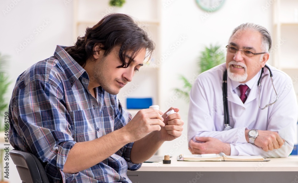 Young male alcoholic visiting old doctor