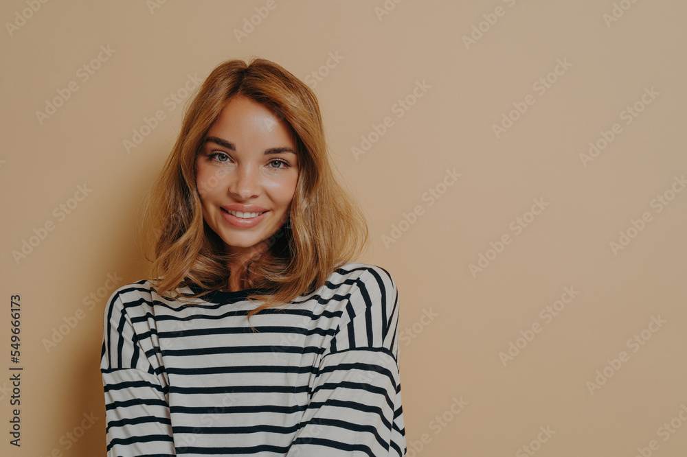 Portrait of lovely woman with minimal natural makeup smiles gently looks directly at camera Portrait of lovely woman with minimal natural makeup smiles gently looks directly at camera