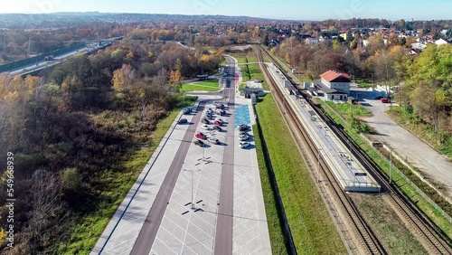 Newly modernized small railway station in Swoszowice district in Krakow, Poland, for fast city trains and regional transportation. Big park and ride P+R parking lot, bus stop and highway in background photo