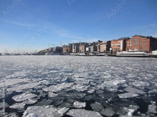 Aker Brygge in Oslo and ice floes in the Oslofjord, Norway, on a beautiful cold sunny day with blue sky.