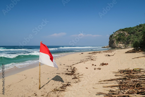 The flag of the Indonesian state that flutters against a blue sky and beach background.  Usually flown on Independence Day on August 17th.