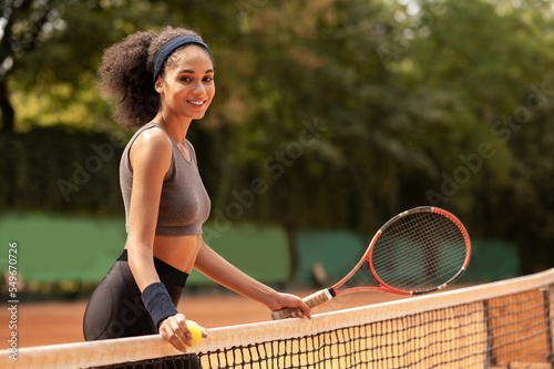 Cute dark-haired girl having a workout at the tennis court photo