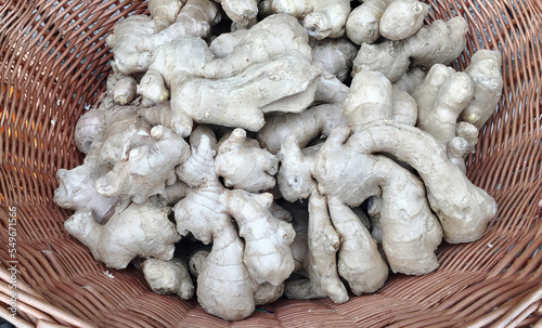 A straw basket with fresh ginger on street pavers.