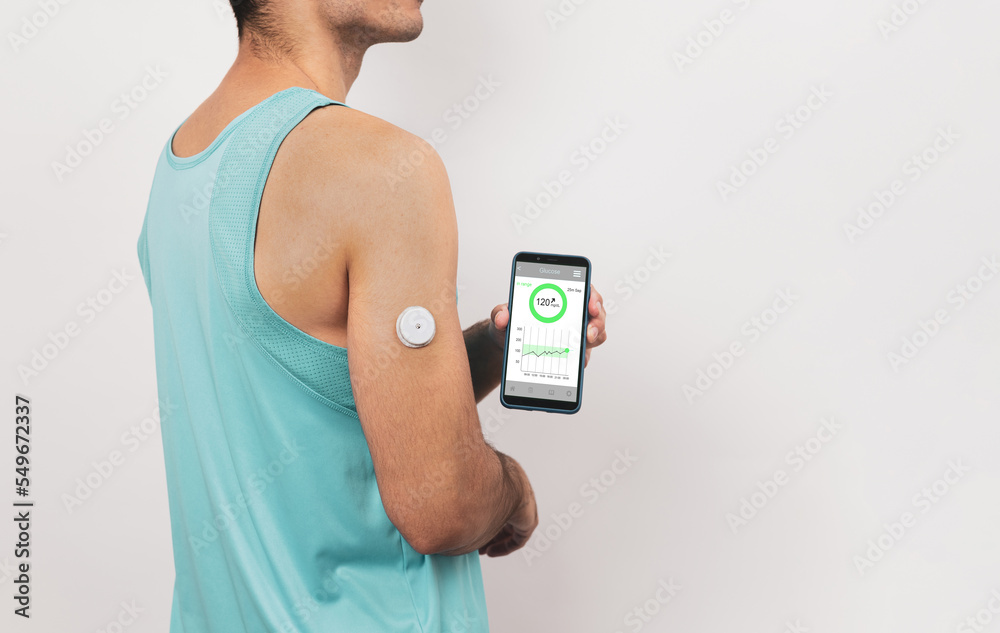 Unrecognizable young athlete shows his mobile with continuous glucose ... - Glucose Sensing Technology For Athletes
