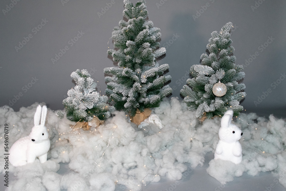Christmas trees in the snow, fluffy snow, two white rabbits. Christmas background.  Happy New Year.