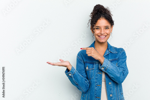 Young african american woman isolated excited holding a copy space on palm.