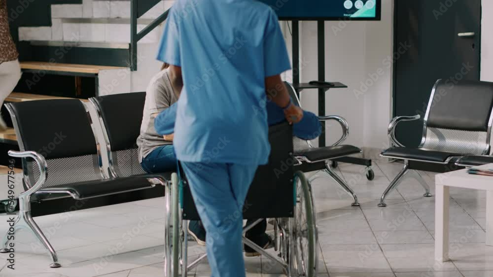 Old person in wheelchair meeting with people in hospital waiting area, talking to woman and small kid in lobby. Elderly adult with disability receiving medical assistance at health center. Old person in wheelchair meeting with people in hospital waiting area, talking to woman and small kid in lobby. Elderly adult with disability receiving medical assistance at health center.