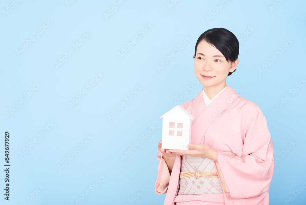 家の模型をもつ着物を着た女性 家の模型をもつ着物を着た女性