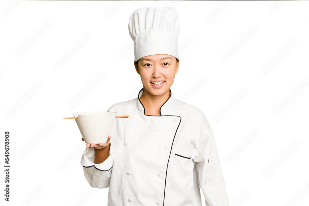 Young chef asian woman holding a bowl of ramen isolated happy, smiling and cheerful. Young chef asian woman holding a bowl of ramen isolated happy, smiling and cheerful.