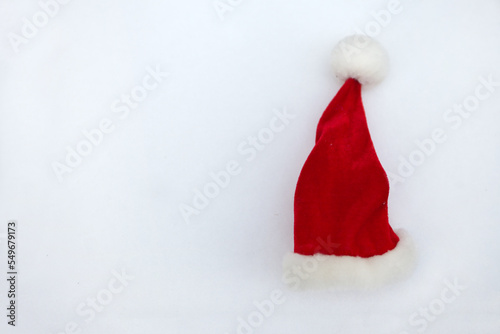 red santa gnome christmas hat on white snow. Santa claus hat on white background.
