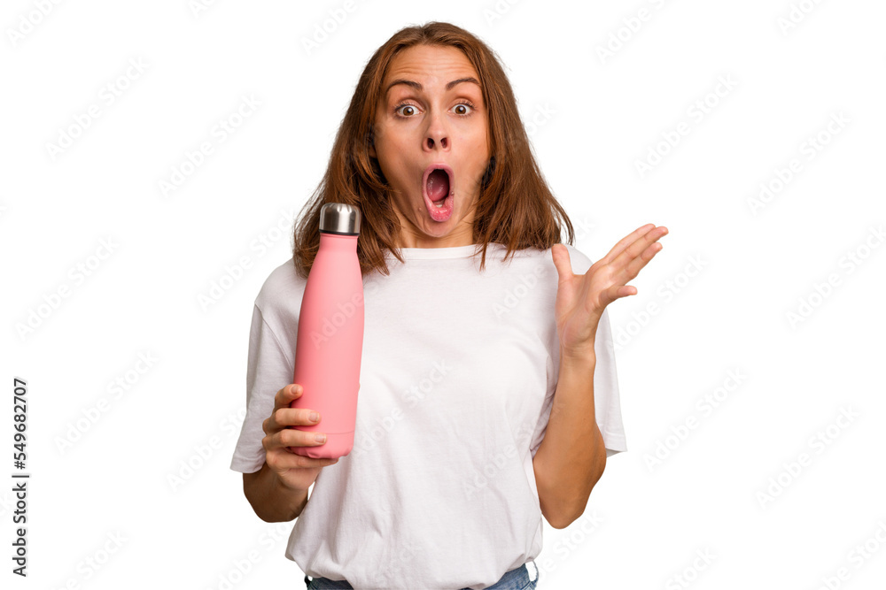 Young caucasian woman holding a pink thermo isolated surprised and shocked. Young caucasian woman holding a pink thermo isolated surprised and shocked.