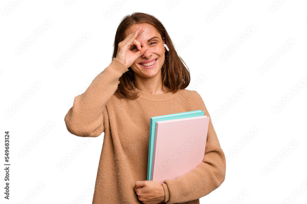 Young student woman holding a books isolated excited keeping ok gesture on eye. Young student woman holding a books isolated excited keeping ok gesture on eye.