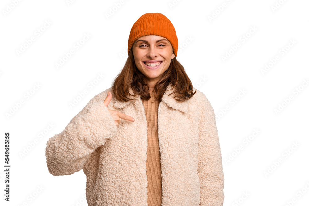 Young caucasian woman wearing winter clothes isolated person pointing by hand to a shirt copy space, proud and confident