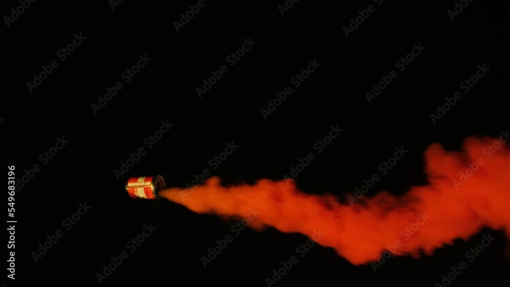 Orange marine emergency smoke flare moving in circular motion with black background