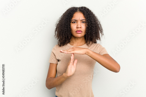 Young african american woman isolated on white background showing a timeout gesture.