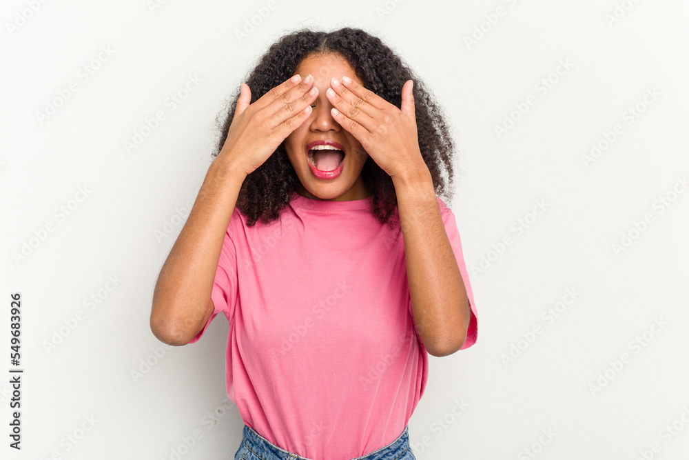 Young african american woman isolated on white background covers eyes with hands, smiles broadly waiting for a surprise. Young african american woman isolated on white background covers eyes with hands, smiles broadly waiting for a surprise.