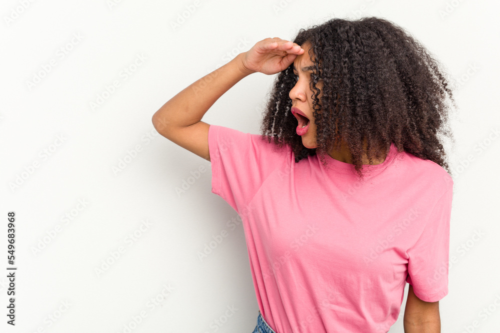 Young african american woman isolated on white background looking far away keeping hand on forehead. Young african american woman isolated on white background looking far away keeping hand on forehead.