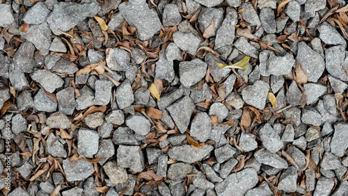 stone aggregate materials for construction. split texture stone with brown leaves photo