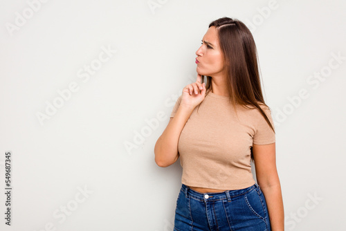 Young caucasian cute woman isolated on white background looking sideways with doubtful and skeptical expression. © Asier