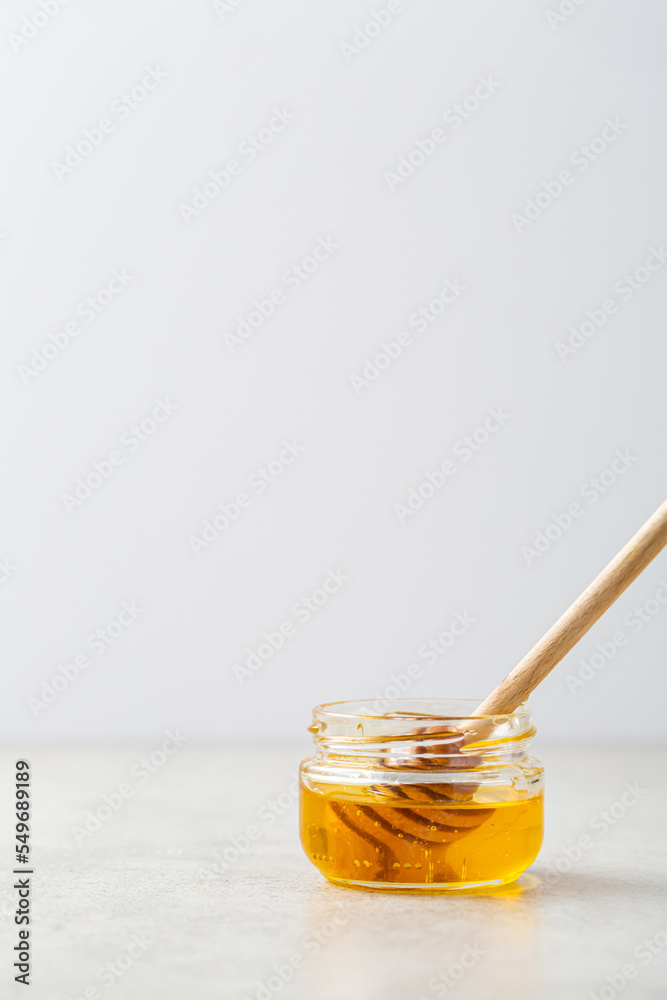 Golden honey and wooden spoon in jar healthy food Golden honey and wooden spoon in jar healthy food