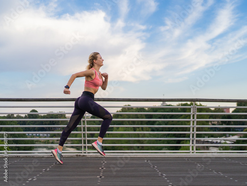 horizontal photo of strong woman running in the city, copy space, fitness concept © victor cuenca lopez