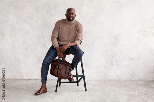 Quadro su tela Stylish man sitting on chair and looking at camera
