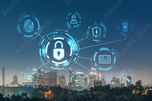 Illuminated Skyline panorama of Los Angeles downtown at night, California, USA. Skyscrapers of LA city. Glowing Padlock hologram. The concept of cyber security to protect confidential information