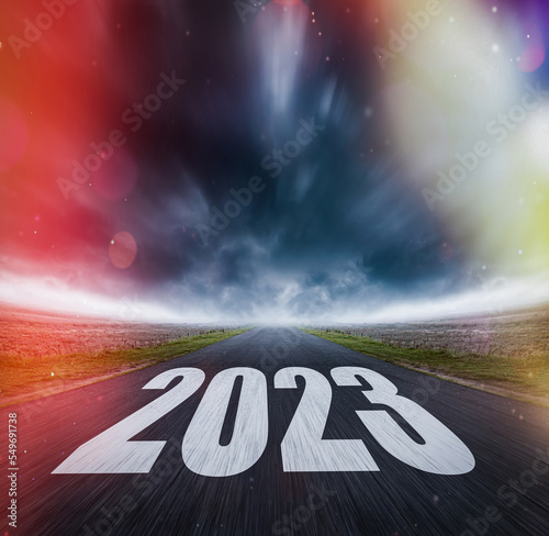 2023 written on highway road in the middle of asphalt road and dark cloudy sky. Future vision 2023