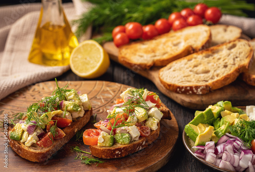 Tasty and healthy avocado, cherry tomatoes and feta cheese sandwiches. Toasts  with avocado, tomatoes and feta cheese.